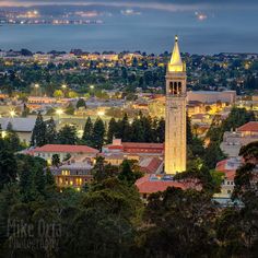 a clock tower in the middle of a city with lights shining on it's sides