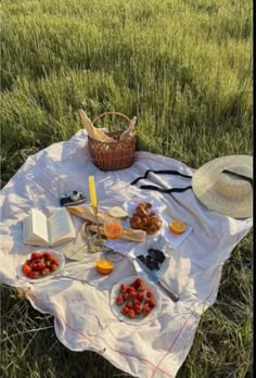 a picnic is set out in the middle of a field with strawberries and cheese