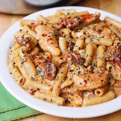 a white plate topped with pasta covered in sauce