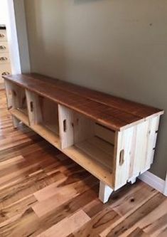 a wooden shelf sitting on top of a hard wood floor next to a white wall