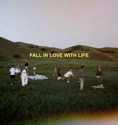 a group of people standing on top of a lush green field next to a rainbow