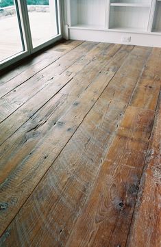 an empty room with wood flooring and open glass doors looking out onto the outdoors