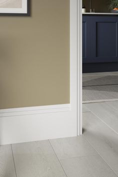 an open door leading to a kitchen with blue cabinets and white tile on the floor