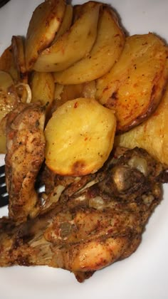 a white plate topped with meat, potatoes and broccoli next to a fork