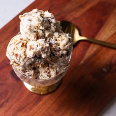 a scoop of ice cream sitting on top of a wooden table next to a spoon