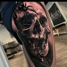 a man's leg with a skull and spider on it