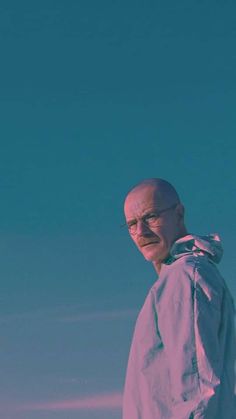 an old man standing in front of a blue sky with no one around him looking at the camera