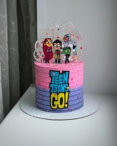 a birthday cake decorated with cartoon characters on it's top and the words teen titans go