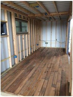 the inside of a shipping container with wood flooring and walls in place for storage