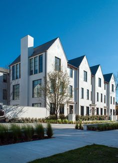 a row of white townhouses on a sunny day