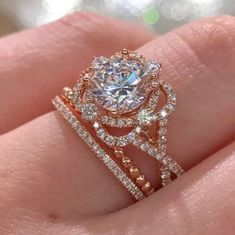 a woman's hand holding an engagement ring with two rows of diamonds on it