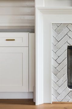 a white brick fireplace in a kitchen next to an oven