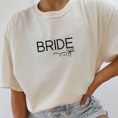 a woman wearing a white t - shirt with the word bride printed on it's chest