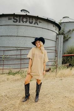 Howdy Tee Dress: This tan, cotton dress features a distressed embellished "HOWDY" print, adding a touch of western charm to your wardrobe. The distressed shoulder edge and collar detail add a unique and stylish touch to this tshirt dress. Perfect for any casual occasion. Codi is wearing size small paired with the Ariat Laramie Boots and Felt Cowboy ProHat Curvy Dress, Heritage Collection, Tee Dress, Cotton Dress, Bottoms Pants, Cotton Dresses, Clothes For Sale, Tshirt Dress, Sweater Top