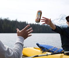 two people on a kayak with a can of beer in their hand