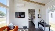 a living room filled with furniture and a flat screen tv on top of a wall