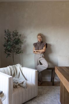 a woman leaning against the wall in her living room