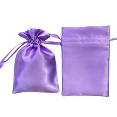 a purple satin bag with a bow on the front and side, sitting next to it's pouch