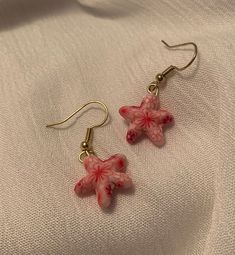 These Dainty, Pink Clay Starfish Drop Earrings are the perfect accessory to complement any outfit. Each pair is handmade and produced in very small quantities, so you're guaranteed to have a unique look.                   ❤ Please note that each earring is not perfeclty identical to its counterpart - our jewelry is made entirely by hand,                        so slight variation does occur.    ------------------------------------------------------------------------------------------------------------------------------------------------------------------------- Caring for your jewelry: ❤ Please handle these earrings with care as they are delicate. Our earrings are made to withstand normal wear, but are vunerable to being damaged if extensive pulling/tugging occurs.  ❤ Avoid getting wet (do Pink Starfish Jewelry For Gift, Adjustable Star Charm Earrings For Gift, Starfish-shaped Nickel-free Earrings For Gifts, Nickel-free Starfish Earrings As Gift, Starfish Shaped Nickel-free Earrings For Gifts, Nickel-free Starfish Earrings For Gifts, Starfish Nickel-free Earrings For Gift, Handmade Star-shaped Earrings For Gift, Starfish Earrings With Star Charm As Gift