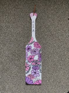 a purple and white flowered bottle shaped toothbrush