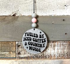 a sign that says fueled by iced coffee and country music hanging on a wooden wall