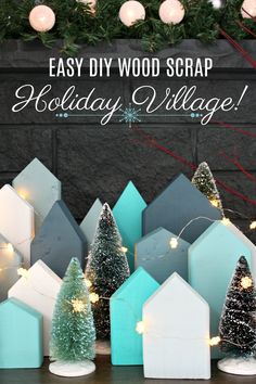 diy wood scrap holiday village with christmas trees and lights in front of a fireplace