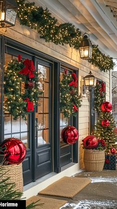 christmas decorations on the front door of a building with lights and wreaths hanging from it's windows