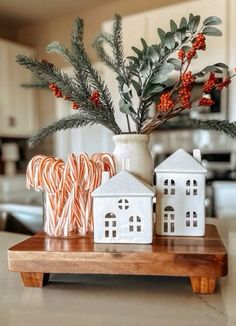 some candy canes are sitting on a wooden tray in front of a christmas tree