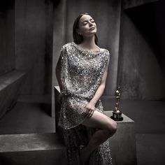 a woman in a silver dress sitting on some steps