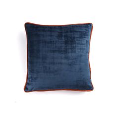 a blue velvet pillow with an orange piping on the front and back side, against a white background