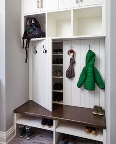 a coat rack with two coats hanging on it's sides and some shoes underneath