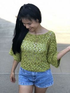 a woman with long black hair is walking down the street