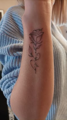 a woman's arm with a tattoo on it that has a rose in the middle