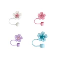 four different colored flower shaped hair clips on a white background with one pink, one blue and one purple