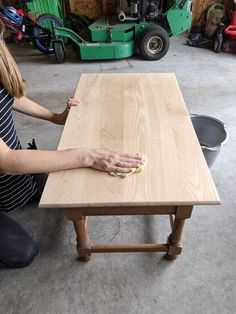 a woman sitting at a table with her hand on the edge of it and cleaning