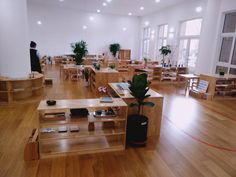 an empty room with tables, chairs and potted plants on the desks in it