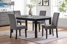 a dining room table with grey chairs around it