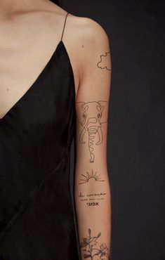 a woman's arm with tattoos on it and an elephant drawn on the side