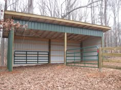 a metal building with two stalls in the woods