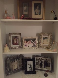 there are many pictures and frames on the shelves in this room, including two framed photos