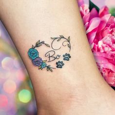 a dog paw and flower tattoo on the ankle