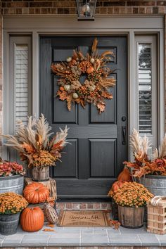 a front door with fall decorations and pumpkins