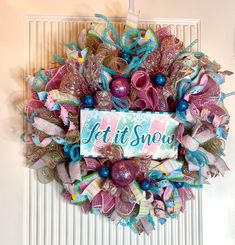 a christmas wreath hanging on the front door with it's snow written on it