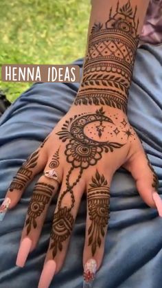 a woman's hand with henna tattoos on it