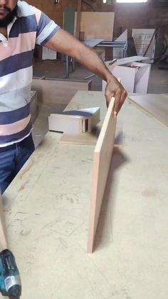 a man standing next to a table with tools on it