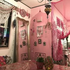 a room with pink walls and mirrors on the wall, decorated with hanging decorations in different colors