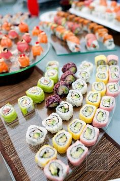 sushi platter with various types of sushi on the trays and plates