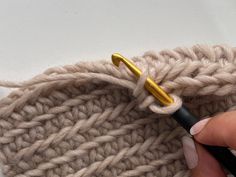 someone is crocheting the side of a knitted sweater