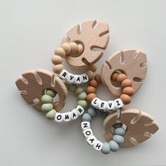 several wooden beads are arranged in the shape of letters that spell out names on each bead