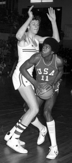 two women playing basketball in an indoor court